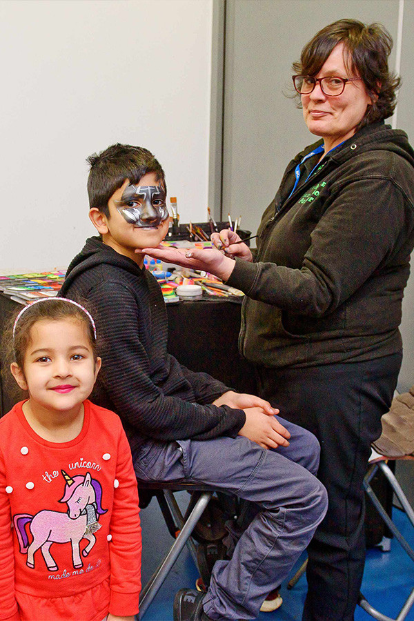 Parent with two children face painting workshop